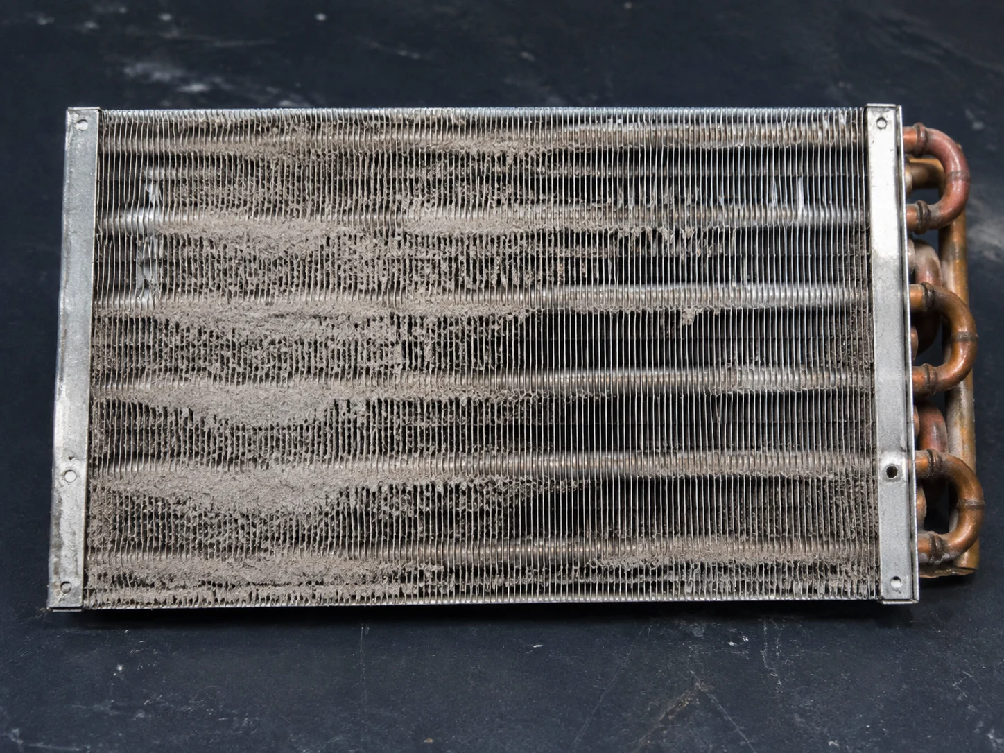 Generated editorial close-up of dust and lint accumulated between HVAC coil fins
